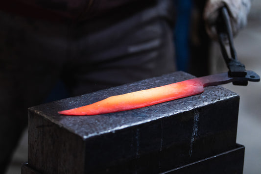 Glowing forged knife blade on a blacksmith anvil