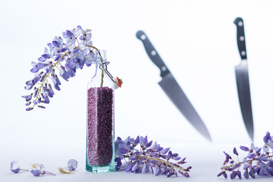 single santoku knife beside a knife block on oak counter, soft side light, quiet editorial kitchen still life, no text n