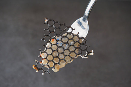 honeycomb textured frying pan being wiped with soft cloth on stove, warm kitchen light, no text no logos