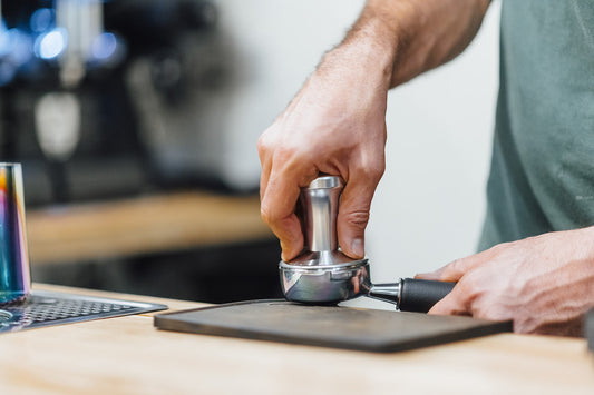 Barista tamping espresso with a portafilter