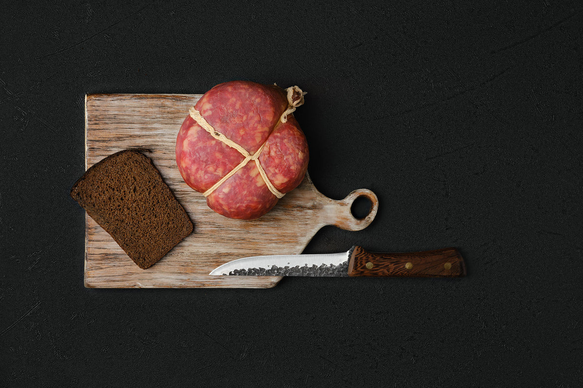 bamboo charcuterie board with cheese and fruit arranged simply, hidden knife drawer slightly open, warm evening light, n